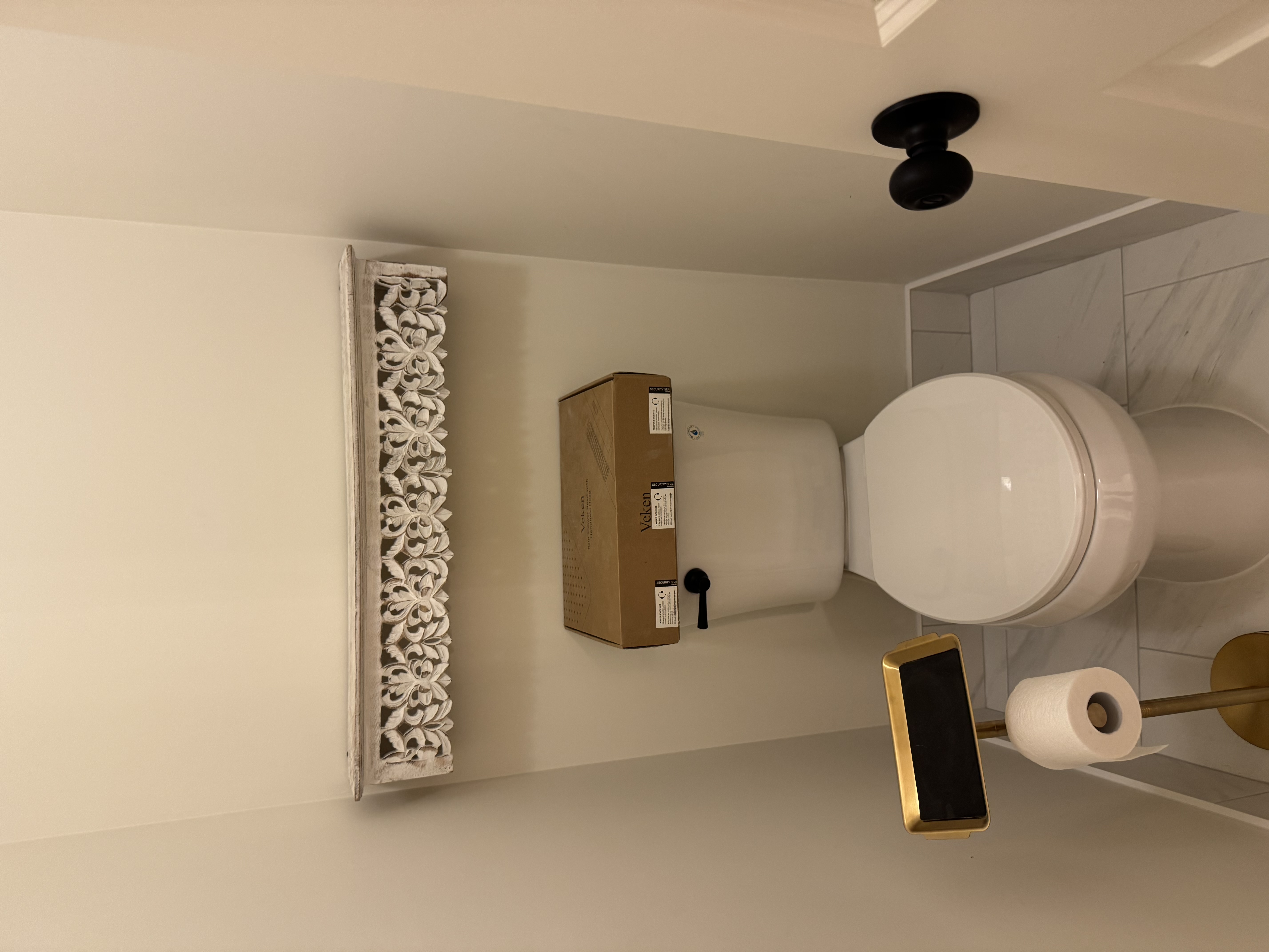Bathroom with decorative shelf and gold fixtures